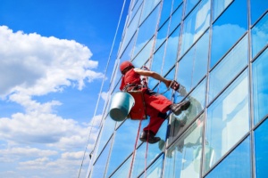 Промышленный альпинист взбирается на офисное здание